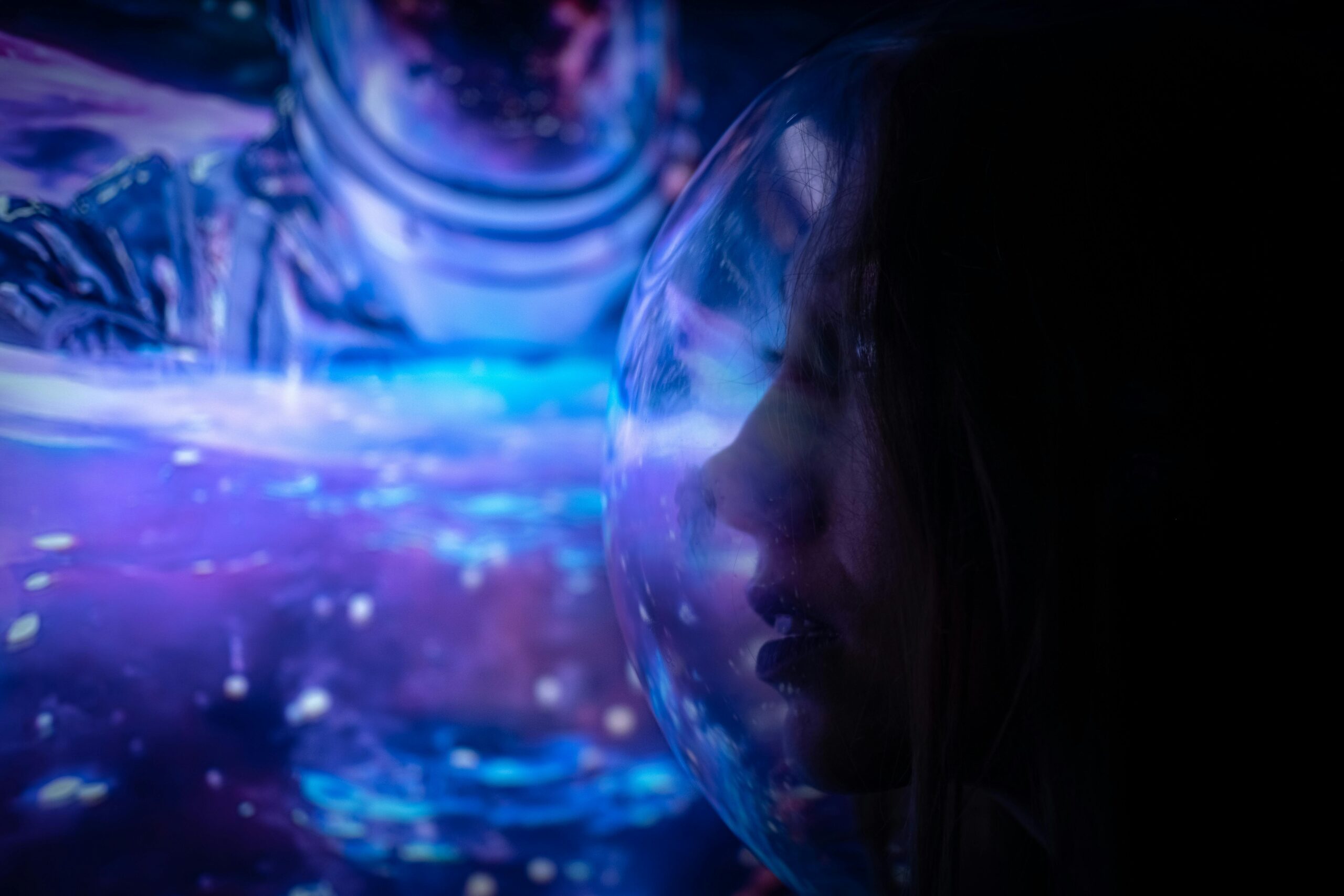 A dreamlike, futuristic portrait of a woman in a space helmet with vibrant illumination.